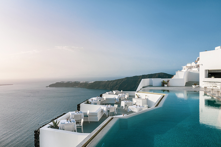 hotel pool and dining area with ocean views at sunset